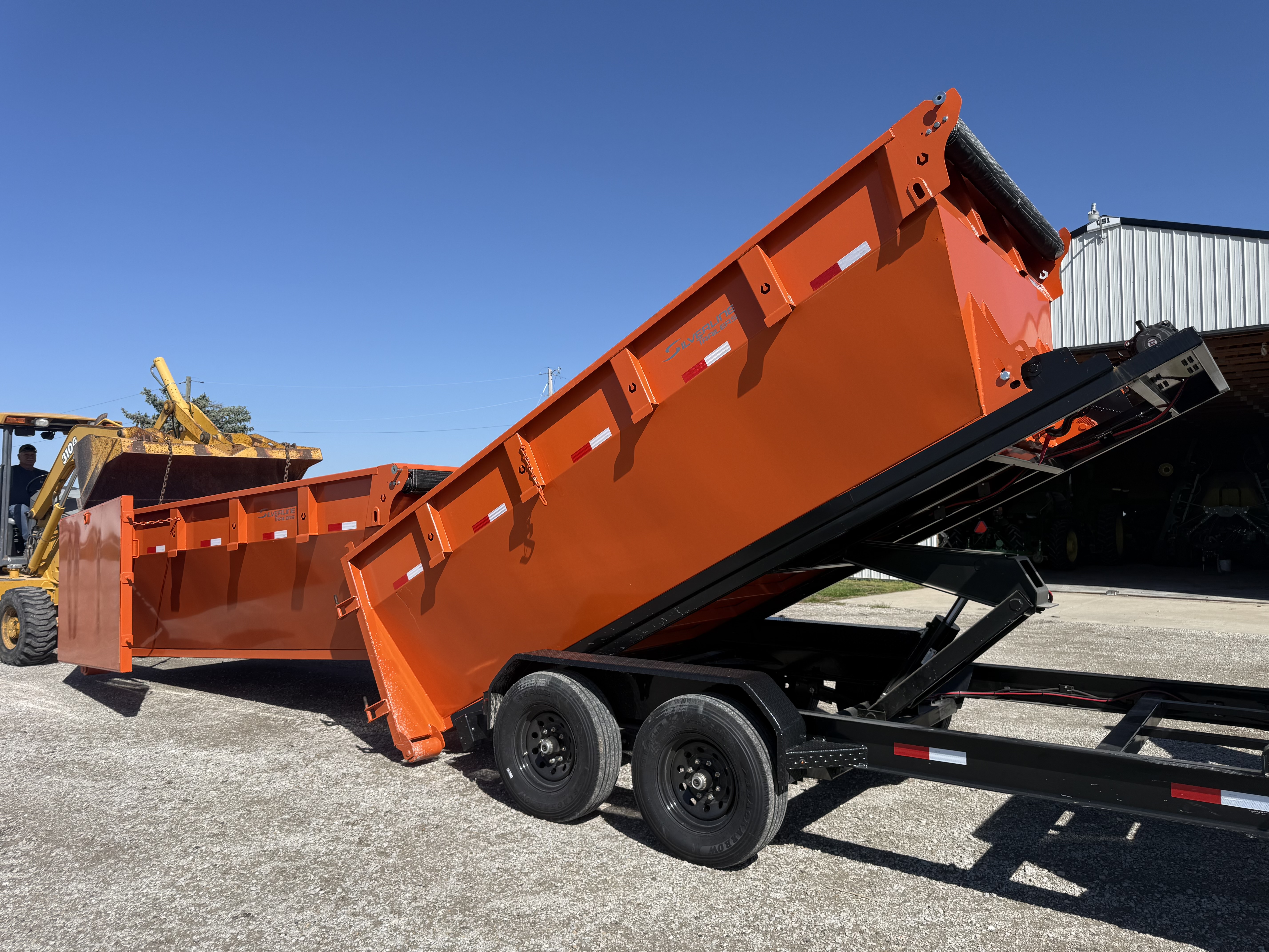 Dump trailer lifting its bed to dump waste